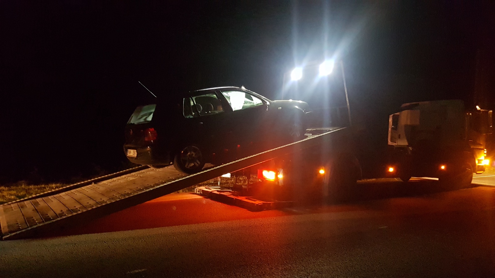 Auto iestidzis smiltīs Jāņu svinību laikā, blakus redzams evakuators. Kā izvilkt auto no smiltīm un pļavām. RS Auto evakuators.
