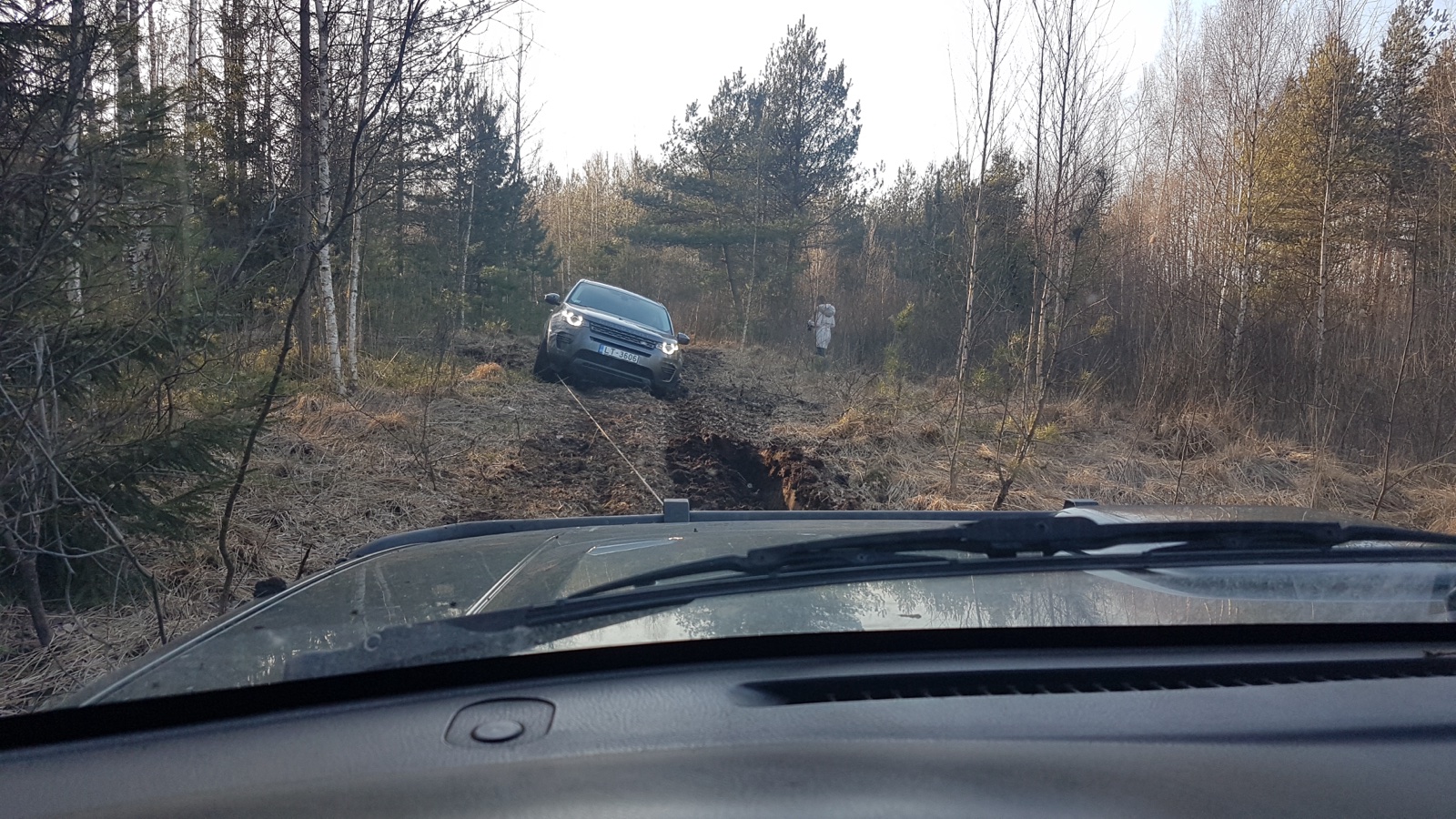 Auto brauc pa grants ceļu, putekļi. Kartera aizsardzība, lauku ceļi, asi akmeņi, autoevakuators, dzinēja aizsardzība.