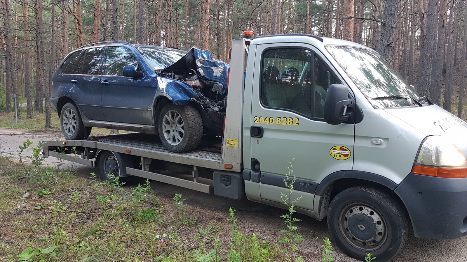 Autoevakuators lietainā laikā sniedz palīdzību autovadītājam