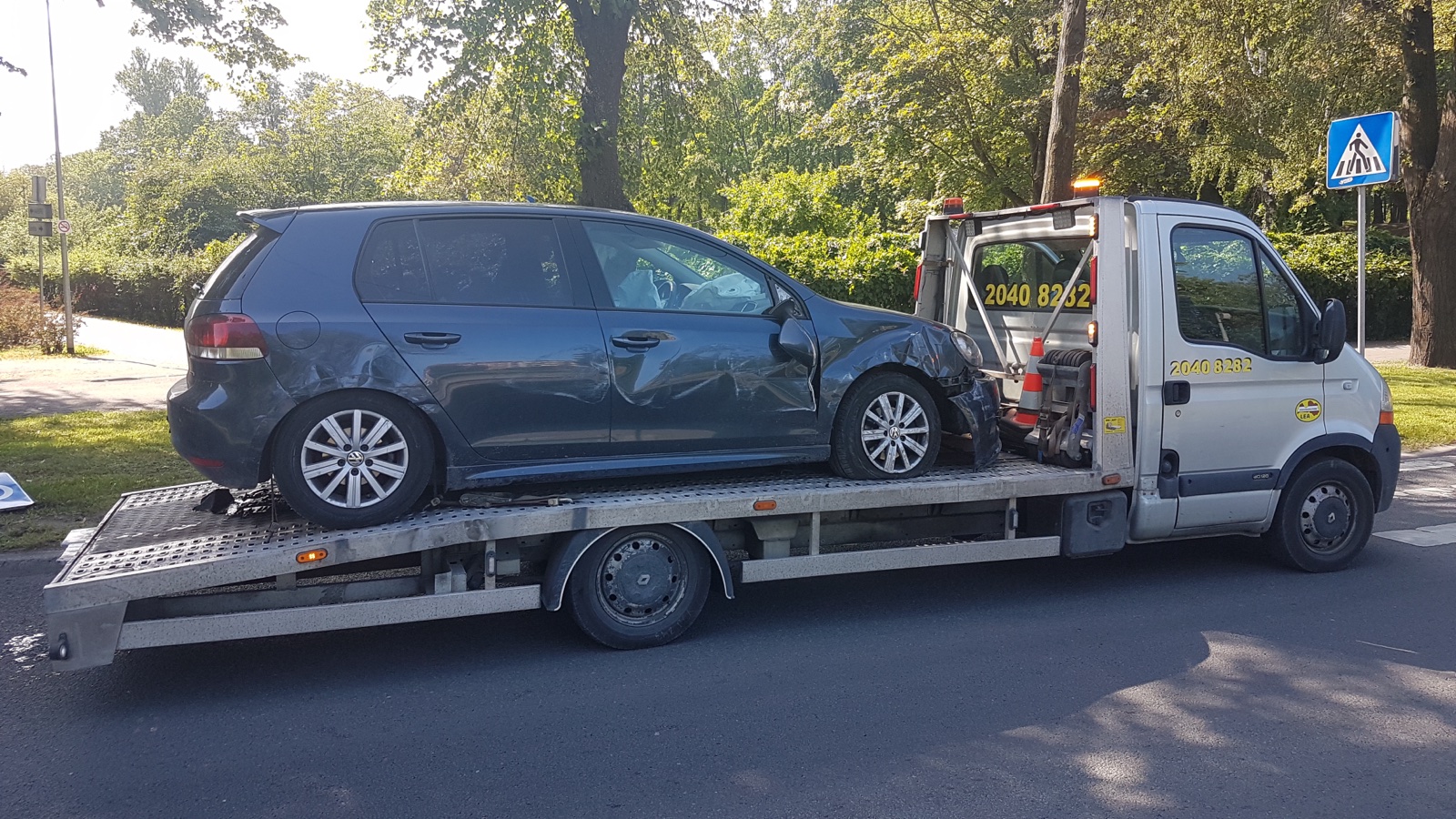 Autoevakuators transportē auto ar bloķētu elektrisko rokasbremzi